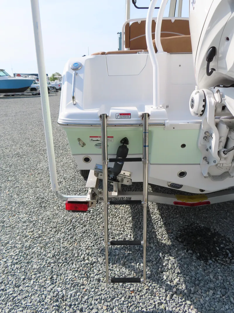 Slide: The Image of 2024 Sea Hunt Ultra 239 SE boat with rear ladder on gravel surface. - 6