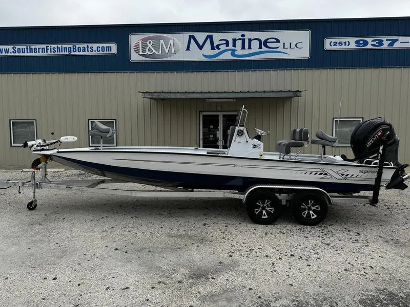 Slide: The Image of 2025 Xpress H24B boat on trailer outside I&M Marine LLC building. - 0