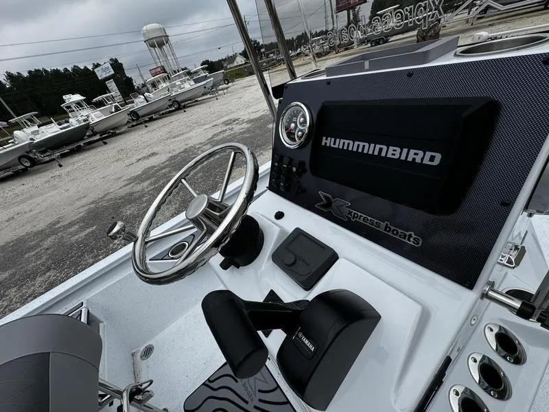 Slide: The Image of 2025 Xpress H24B boat dashboard with Humminbird electronics, steering wheel, and control panel. - 5