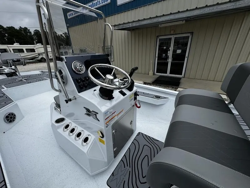 Slide: The Image of 2025 Xpress H24B boat console with steering wheel and seating, displayed outdoors. - 9