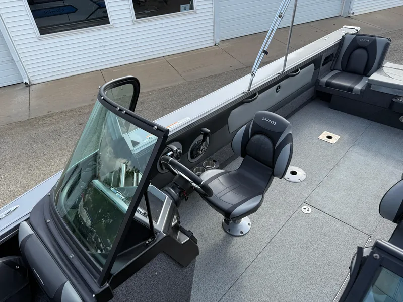 Slide: The Image of 2023 Lund 2275 Baron boat interior with steering console and seating. - 13
