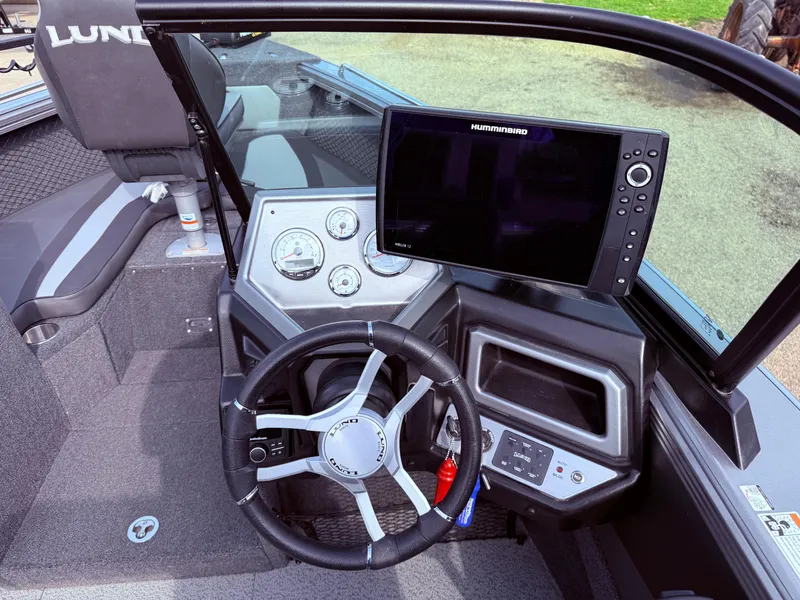 Slide: The Image of 2023 Lund 2275 Baron boat dashboard with steering wheel and navigation display. - 15