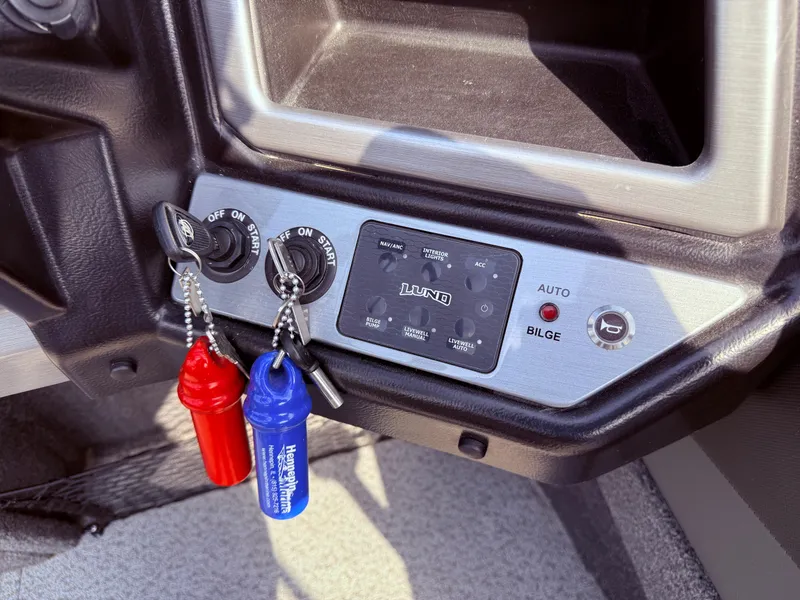 Slide: The Image of Control panel of 2023 Lund 2275 Baron boat with ignition keys and bilge switch. - 16