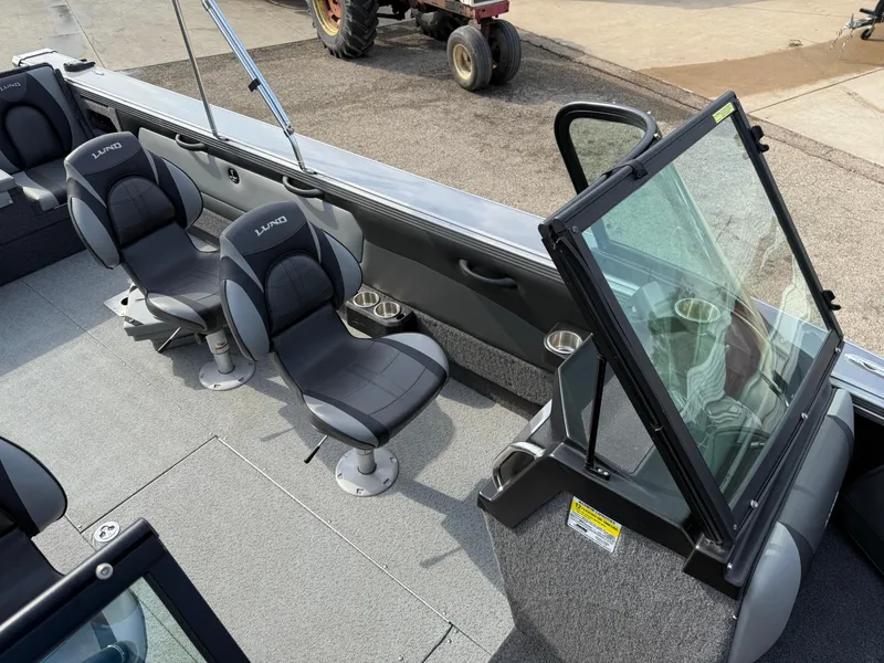 Slide: The Image of 2023 Lund 2275 Baron boat interior with seating and windshield, showcasing modern design. - 18