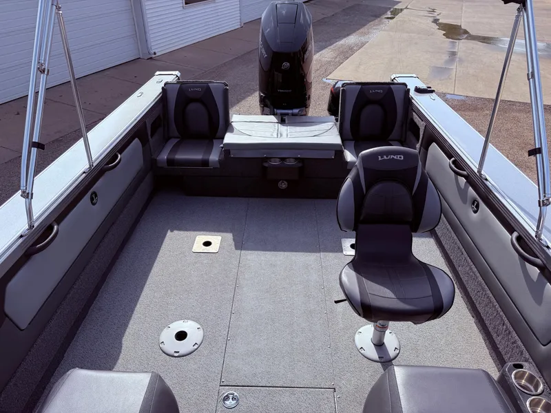Slide: The Image of 2023 Lund 2275 Baron boat interior with seating and motor, showcasing spacious design. - 21