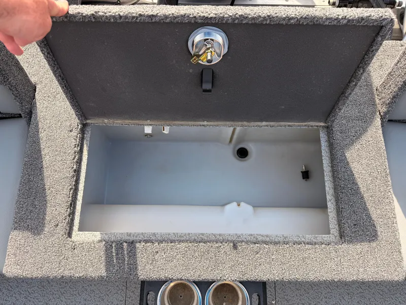 Slide: The Image of 2023 Lund 2275 Baron boat storage compartment with open lid, showing interior space. - 26