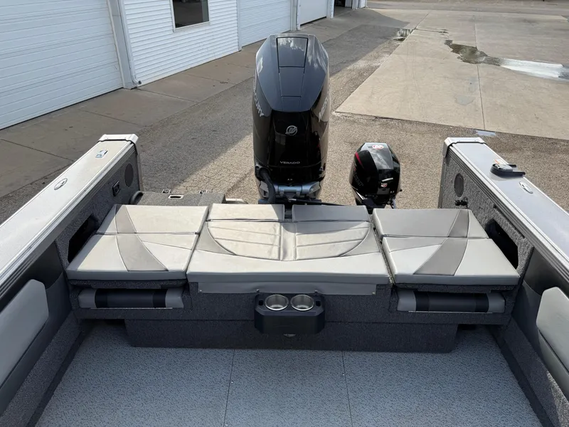 Slide: The Image of 2023 Lund 2275 Baron boat interior with cushioned seating and dual outboard motors. - 30