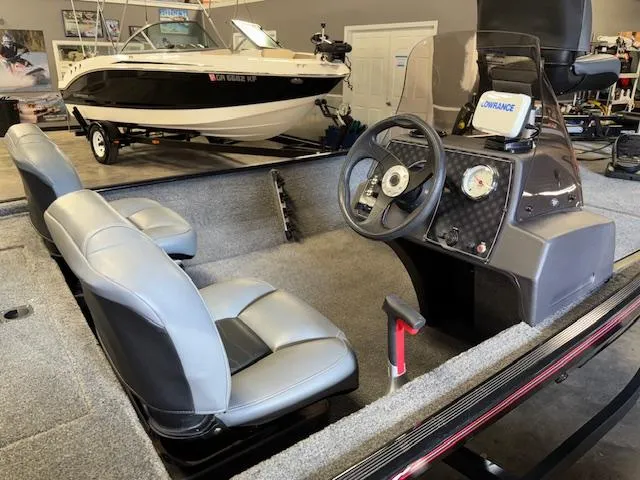 Slide: The Image of 2023 Bass Tracker Classic XL boat interior with steering console and seating in showroom. - 10