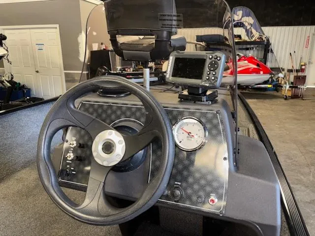 Slide: The Image of 2023 Bass Tracker Classic XL boat dashboard with steering wheel and navigation system. - 11