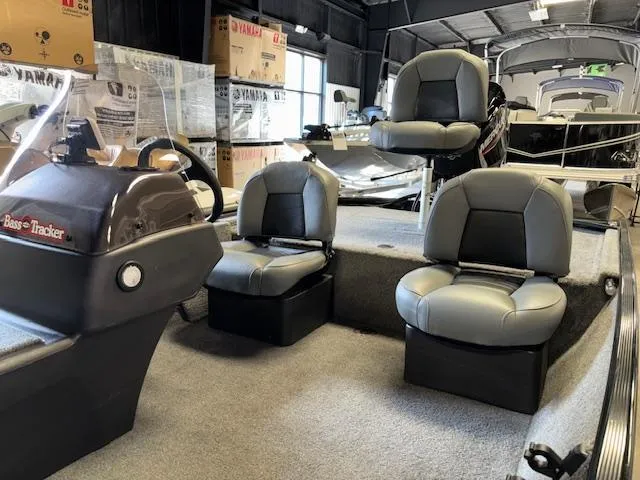 Slide: The Image of 2023 Bass Tracker Classic XL boat interior with three gray seats and steering console. - 14