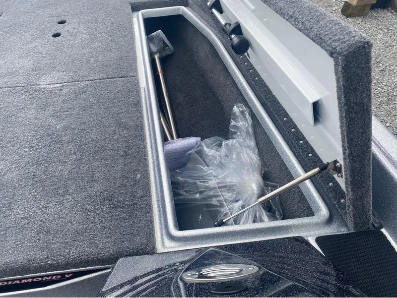 Slide: The Image of Open storage compartment in a 2025 Phoenix 518 Pro boat, showing tools and packaging. - 14