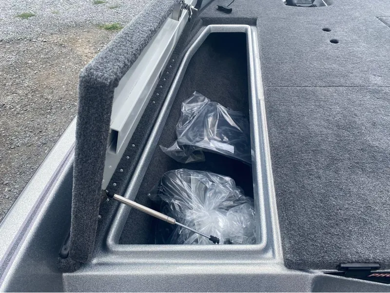 Slide: The Image of Open storage compartment in 2025 Phoenix 518 Pro boat, showing interior with plastic-wrapped items. - 15