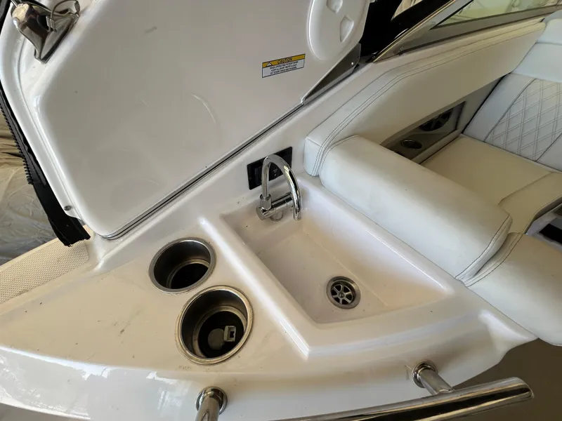 Slide: The Image of 2021 Regal 2800 Express boat interior with sink and cup holders. - 11