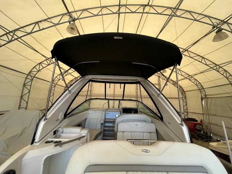 Slide: The Image of 2021 Regal 2800 Express boat interior under a canopy, showcasing seating and helm area. - 13