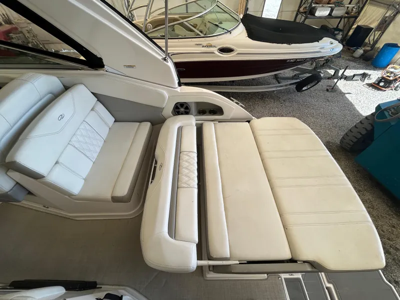 Slide: The Image of 2021 Regal 2800 Express boat interior with white cushioned seating in a garage. - 7