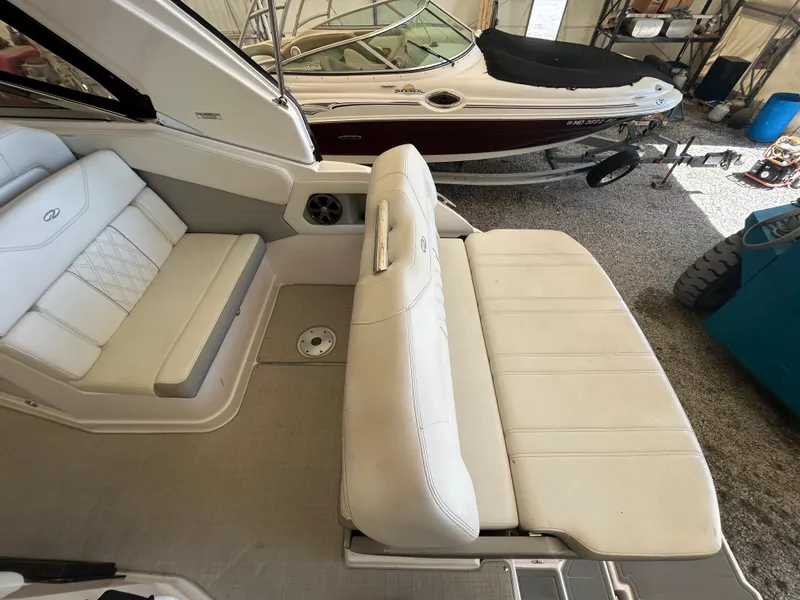 Slide: The Image of 2021 Regal 2800 Express boat interior with white seating in a garage setting. - 8