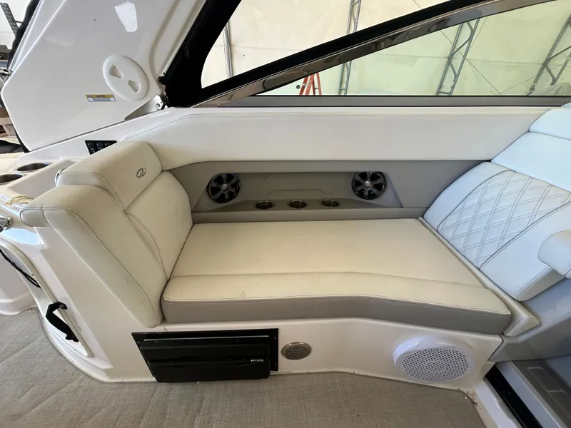 Slide: The Image of 2021 Regal 2800 Express boat interior with white seating and built-in speakers. - 9