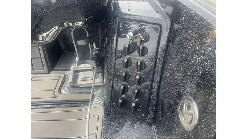Slide: The Image of Control panel of a 2025 Phoenix 920 Elite boat with switches and key ignition. - 9
