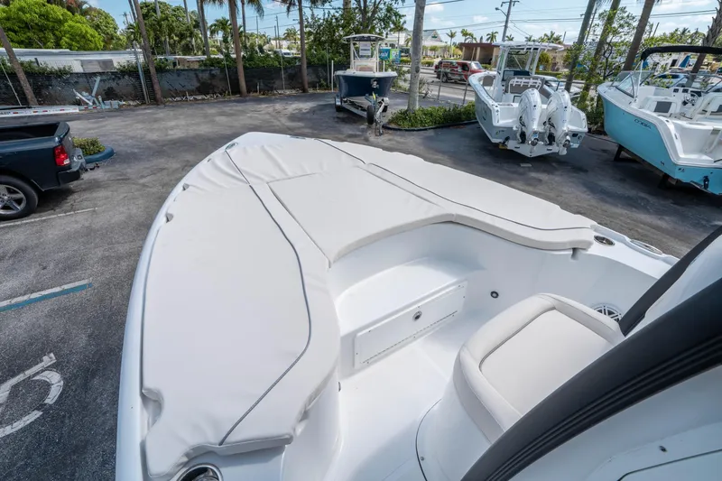 Slide: The Image of 2025 Sea Hunt BX 22 BR boat with cushioned seating, parked outdoors. - 20