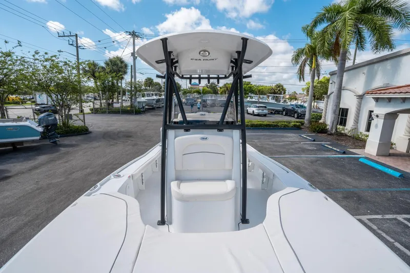 Slide: The Image of 2025 Sea Hunt BX 22 BR boat with T-top, parked outdoors under blue sky. - 21