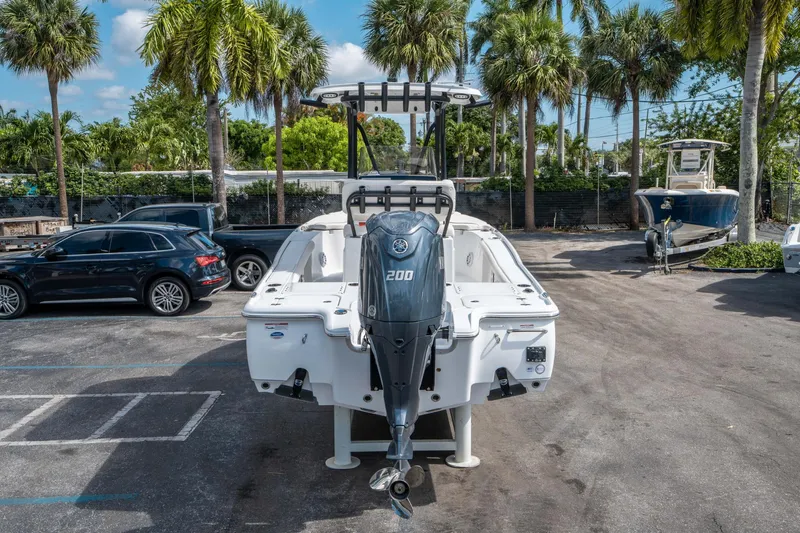 Slide: The Image of 2025 Sea Hunt BX 22 BR boat with Yamaha 200 engine, parked outdoors with palm trees. - 3