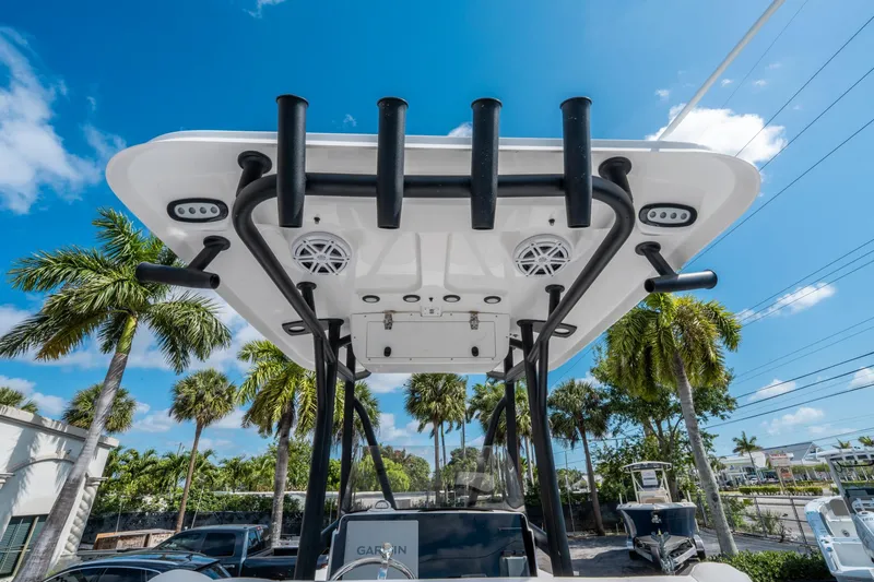 Slide: The Image of 2025 Sea Hunt BX 22 BR boat with T-top and rod holders under a clear blue sky. - 18