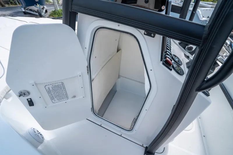 Slide: The Image of 2025 Sea Hunt BX 22 BR boat console storage compartment with open door. - 19