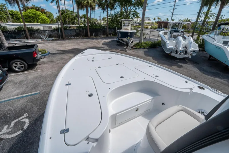 Slide: The Image of 2025 Sea Hunt BX 22 BR boat deck in a marina with surrounding boats and vehicles. - 23