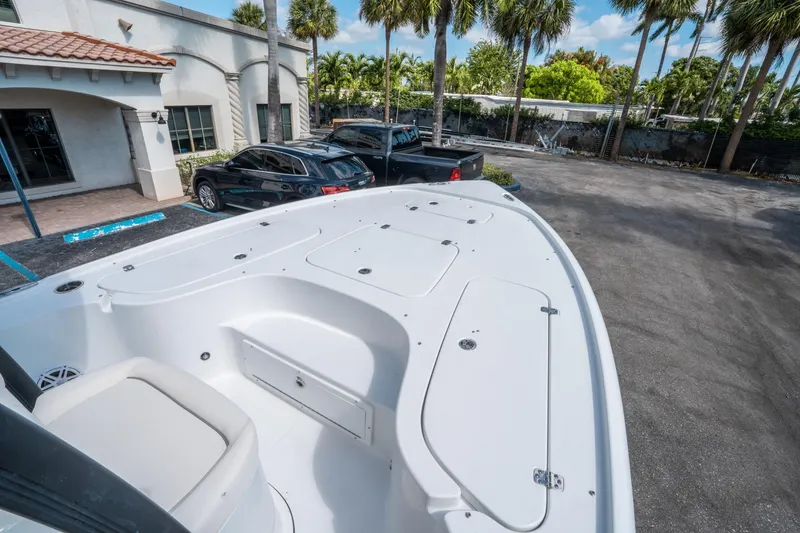 Slide: The Image of 2025 Sea Hunt BX 22 BR boat deck with storage compartments, parked near palm trees. - 24