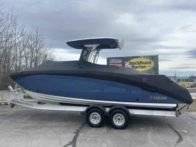 Slide: The Image of 2025 Yamaha Boats 252 FSH Sport on trailer, covered, parked outdoors. - 7
