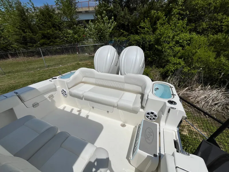 Slide: The Image of 2025 Key West 291 FS boat interior with seating and twin engines, surrounded by greenery. - 6
