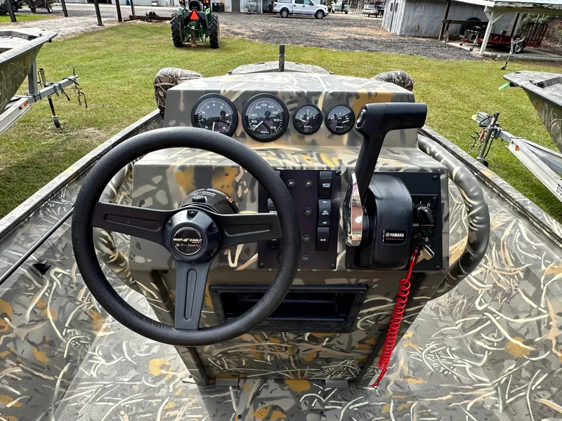 Slide: The Image of 2025 War Eagle 961 Blackhawk boat dashboard with steering wheel and control panel. - 3