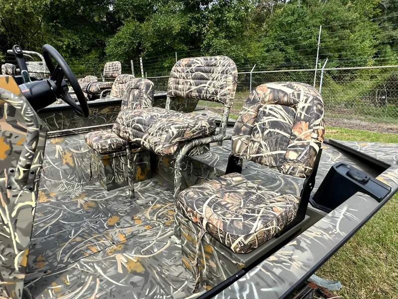 Slide: The Image of 2025 War Eagle 961 Blackhawk boat with camouflage seating, parked outdoors. - 4