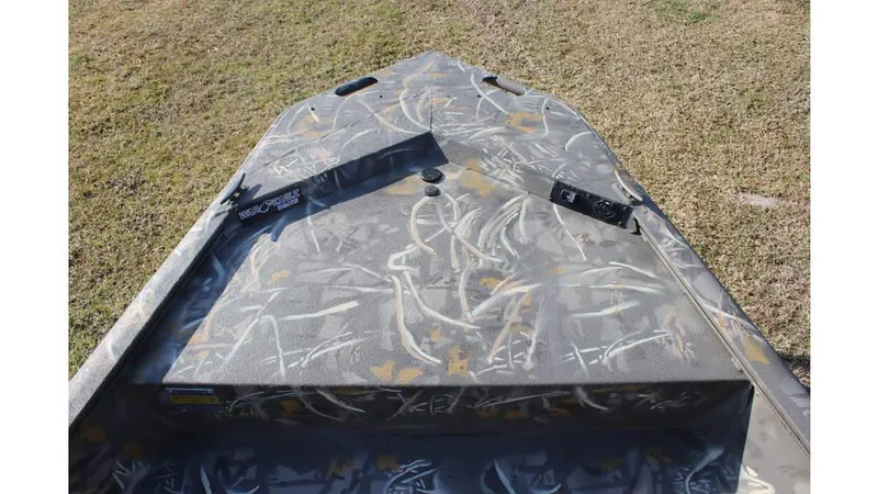 Slide: The Image of 2025 War Eagle 961 Blackhawk boat with camouflage design on grassy terrain. - 5