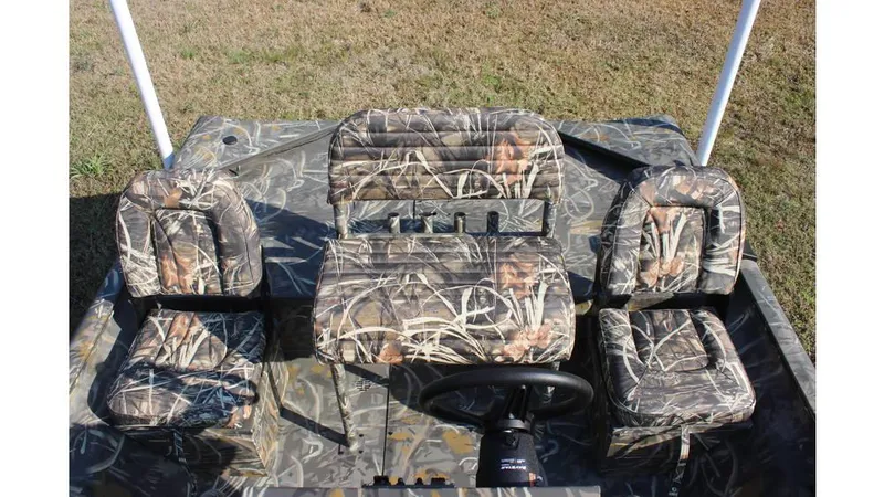 Slide: The Image of 2025 War Eagle 961 Blackhawk boat interior with camouflage seating and steering wheel. - 7