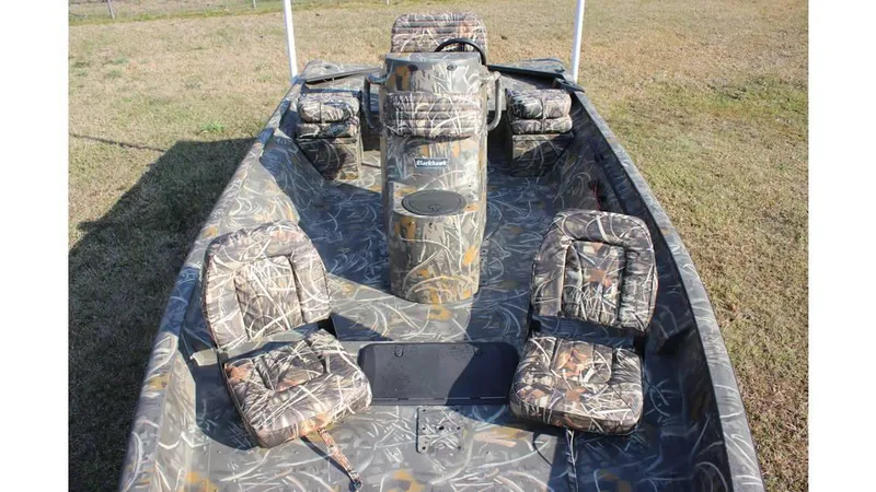 Slide: The Image of 2025 War Eagle 961 Blackhawk boat with camouflage seating and console on grassy terrain. - 8