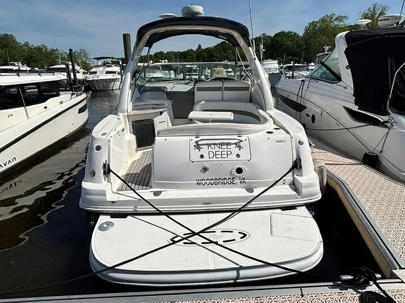 Slide: The Image of 2006 Sea Ray 320 Sundancer docked at marina, rear view with open cockpit. - 2