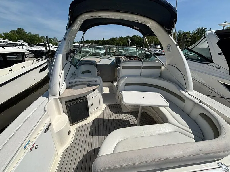 Slide: The Image of 2006 Sea Ray 320 Sundancer boat interior with seating and table, docked at marina. - 3