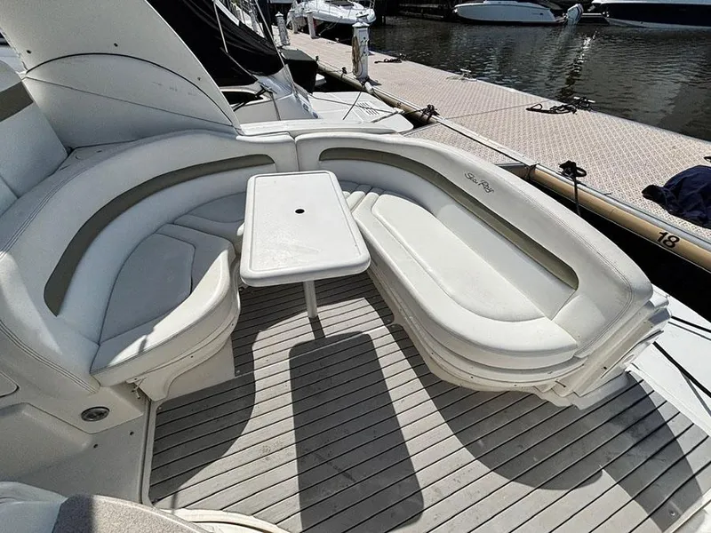 Slide: The Image of 2006 Sea Ray 320 Sundancer boat with white seating and table on deck. - 8