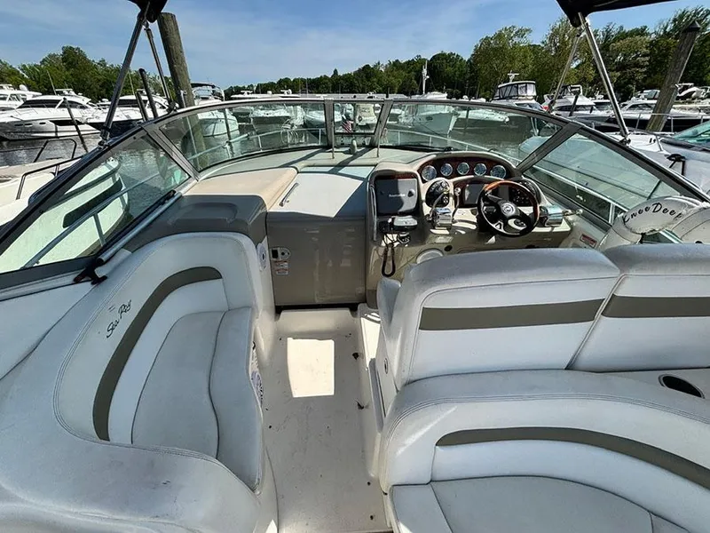 Slide: The Image of 2006 Sea Ray 320 Sundancer boat interior with white seating and control panel. - 9