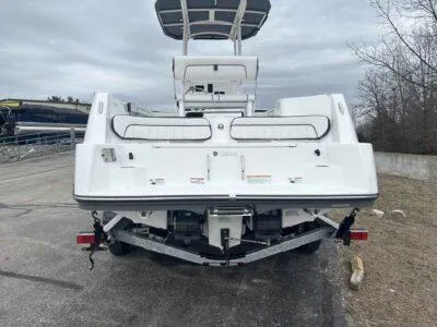 Slide: The Image of 2025 Yamaha Boats 222 FSH Sport, rear view, parked on a trailer, overcast sky. - 6