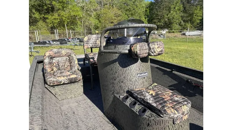 Slide: The Image of 2025 War Eagle 2170 Blackhawk boat with camouflage seating, parked outdoors. - 4