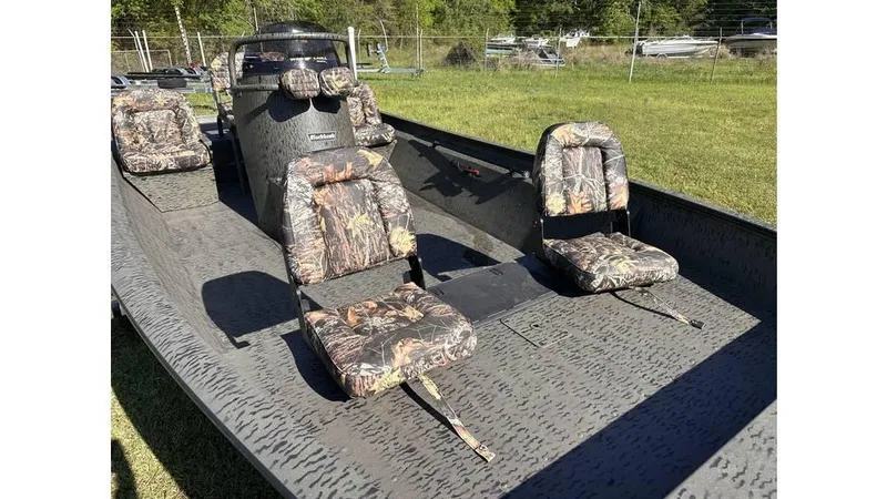 Slide: The Image of 2025 War Eagle 2170 Blackhawk boat with camouflage seats on grassy area. - 6