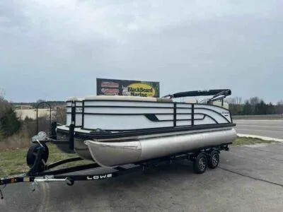 Slide: The Image of 2025 Lowe SS 210 WT pontoon boat on trailer, parked near highway. - 6