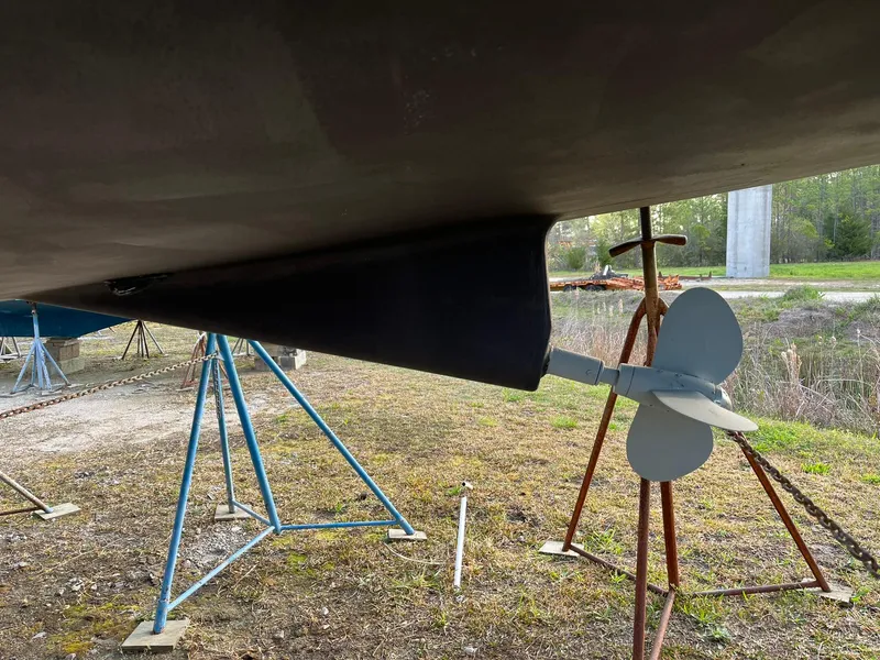 Slide: The Image of Beneteau 423 sailboat propeller and rudder, 2007 model, on dry dock with stands. - 12