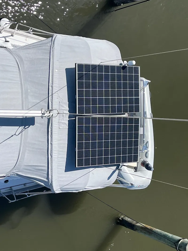 Slide: The Image of Beneteau 423 sailboat with solar panels on deck, 2007 model, docked on calm water. - 16