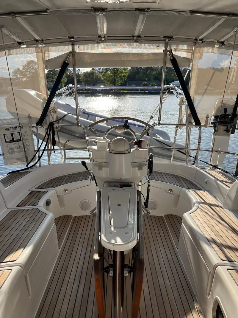 Slide: The Image of 2007 Beneteau 423 yacht cockpit with steering wheel, wooden deck, and water view. - 18