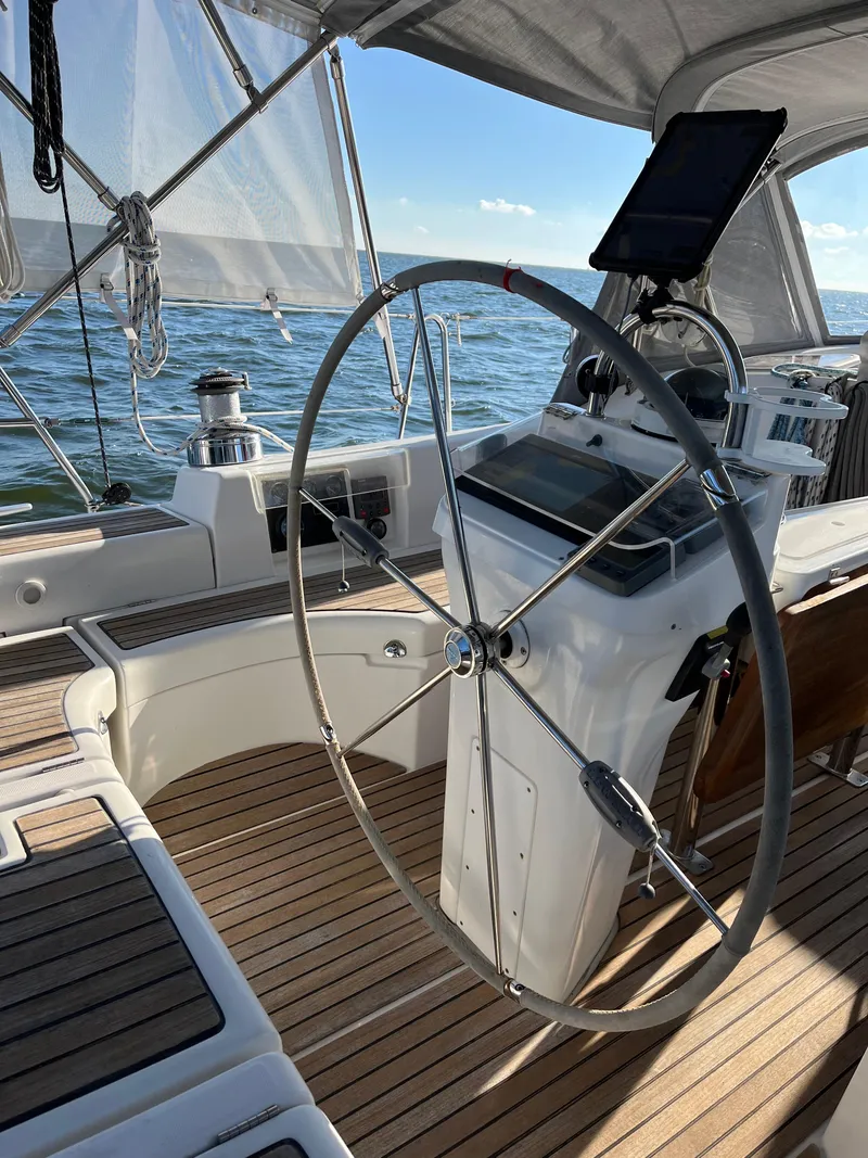 Slide: The Image of 2007 Beneteau 423 sailboat cockpit with steering wheel, ocean view, and wooden deck. - 19