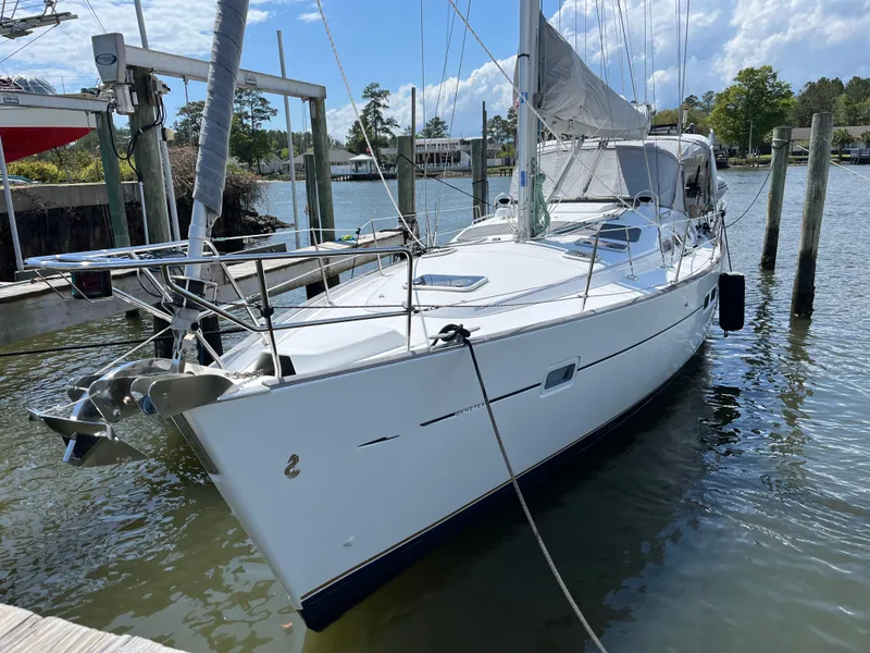 Slide: The Image of 2007 Beneteau 423 sailboat docked in a marina, featuring sleek white design and modern rigging. - 2
