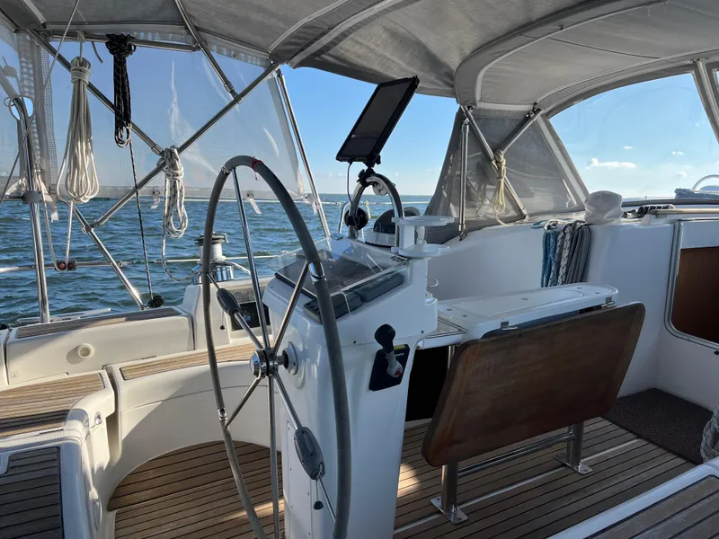 Slide: The Image of Beneteau 423 sailboat cockpit, 2007 model, featuring steering wheel and navigation equipment on open water. - 20
